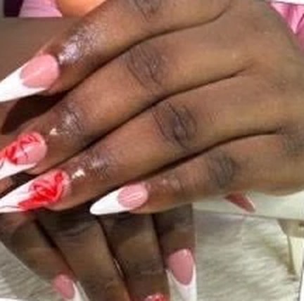 Stiletto nails with white French tips and red hand-painted accents